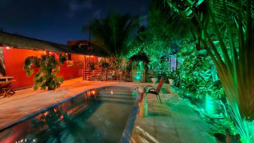 a house with a swimming pool at night at Casa de hóspedes Balibar Cumbuco in Cumbuco