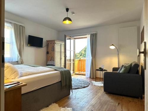 a bedroom with a bed and a chair and a window at BeimSchmied in Schechen