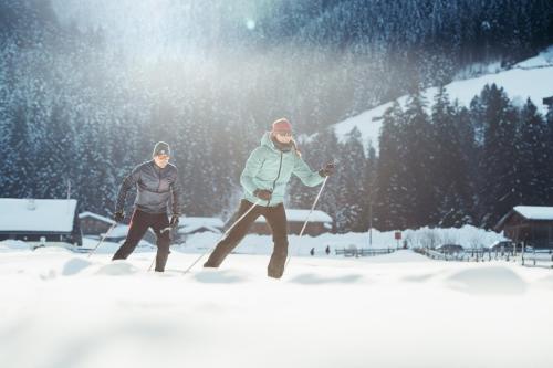 two men are walking in the snow on skis at Neueröffnung ELVA PREMIUM APARTMENT HOTEL inklusive Sommerpass STUBAI SUPER CARD in Neustift im Stubaital