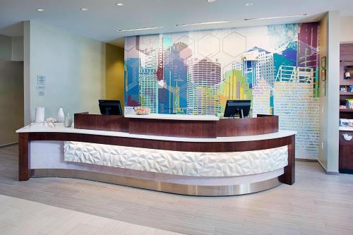 a lobby with a large mural of a city at SpringHill Suites by Marriott Carle Place Garden City in Carle Place