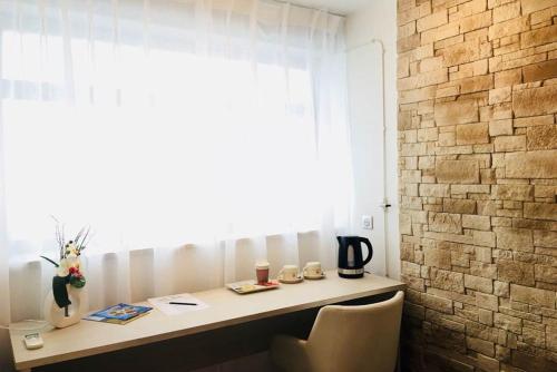 a desk in a room with a window at Hôtel Terranostra in Tarascon-sur-Ariège
