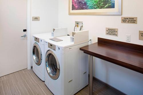 a laundry room with a washer and dryer at SpringHill Suites by Marriott Carle Place Garden City in Carle Place