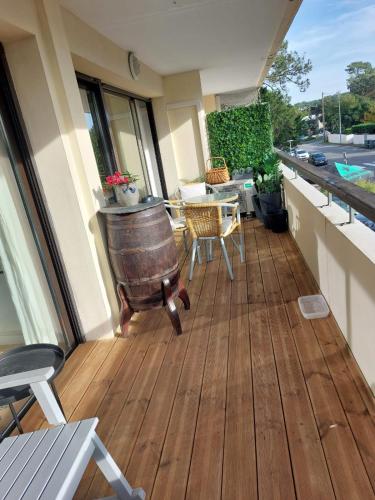 - un balcon avec une table et un tonneau dans un bâtiment dans l'établissement Appartement avec balcon au pied du port, à Capbreton