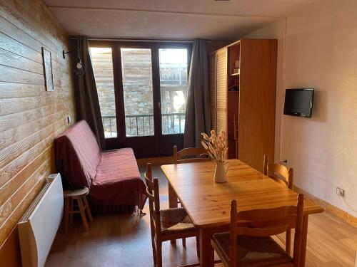 une salle à manger avec une table et des chaises et une fenêtre dans l'établissement Studio cabine, aux Angles