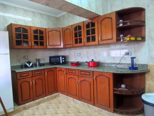 a kitchen with wooden cabinets and a counter top at Where landsacpe view meets Luxury in Cairo