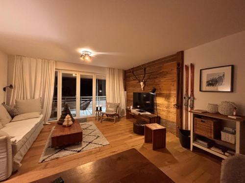 a living room with a couch and a tv at Stube9 am Feldberg, direkt an der Skipiste, Ski in-Ski out in Feldberg
