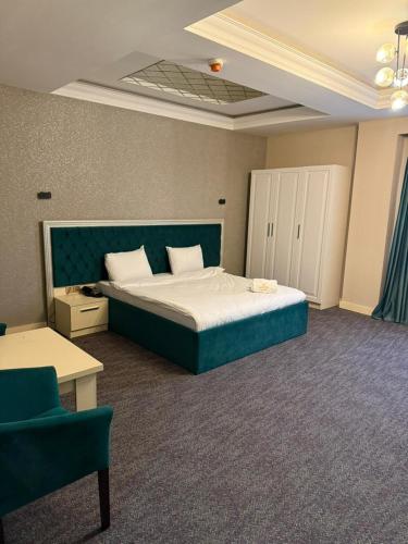 a bedroom with a large bed with a blue headboard at Black Mont İnn Hotel in Baku