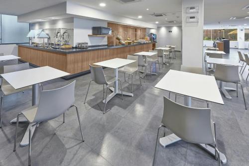 a cafeteria with tables and chairs and a kitchen at City Express by Marriott Saltillo Norte in Saltillo