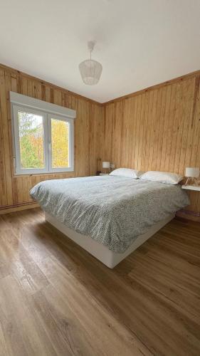 a bedroom with a large bed and wooden walls at Pico Cerler in Cerler