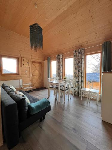 una sala de estar con un sofá y una mesa en Domki Habzówka, en Ostre