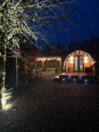 a lit up backyard at night with a pergola at Loch Ness Pods in Fort Augustus