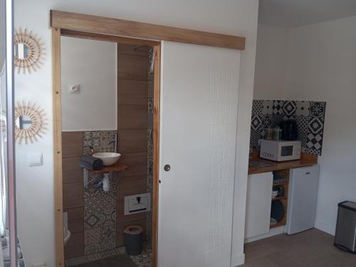 une cuisine avec une porte menant à une pièce avec un comptoir dans l'établissement La petite cabane, à Villebarou