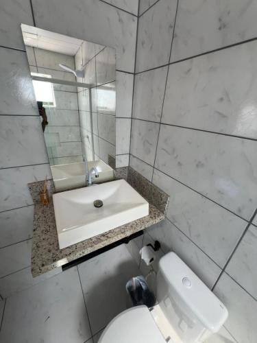 フロリアノポリスにあるCasaの洗面台とトイレを備えた白いバスルーム
