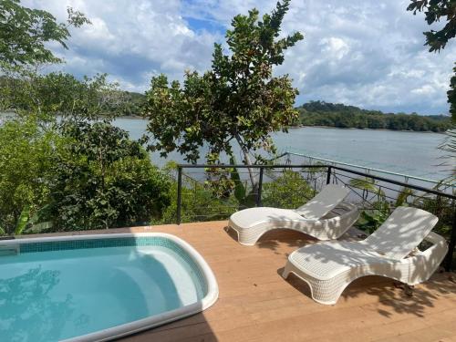 ボカ・チカにあるVillas Isla Escondidaの海の景色を望むスイミングプール(ラウンジチェア2脚付)