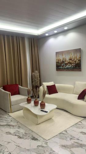 a living room with white couches and a table at Scarlett Apartments in Monrovia