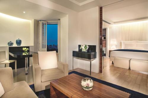 a bedroom with a bed and a living room at The Ritz-Carlton, Bahrain in Manama