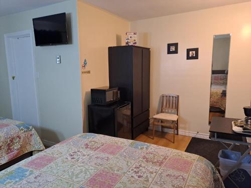 a bedroom with a bed and a dresser and a television at Three Island Motel in Bobcaygeon