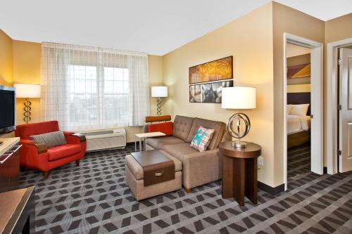 a hotel room with a couch and a chair at TownePlace Suites Republic Airport Long Island Farmingdale in Farmingdale