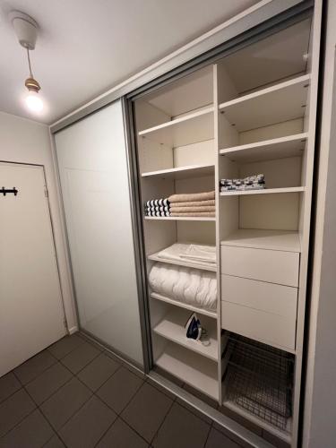 a walk in closet with white cabinets at Modern Studio with Balcony in City Center in Helsinki