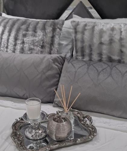 a tray with a candle and glasses on a bed at Lerewa in Gaborone