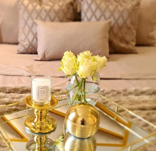 a vase of yellow flowers and a candle on a table at Lerewa in Gaborone