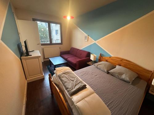 une chambre avec un lit et un canapé dans l'établissement Logements Gare Brignoud, à Villard-Bonnot