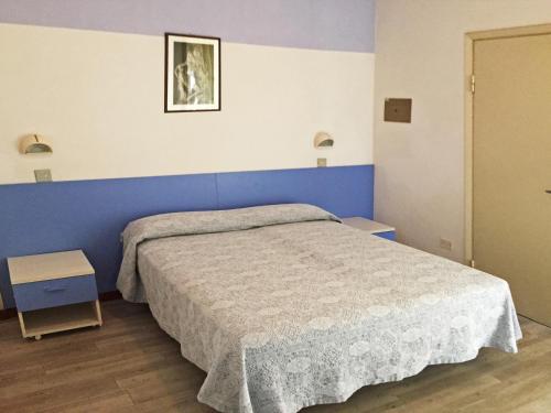a bedroom with a bed and a blue wall at B&B Promenade Hotel Simple con Piscina in Milano Marittima