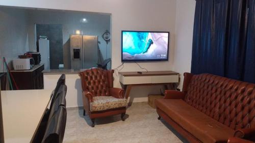 Una sala de estar con un sofá y un piano. en Casa Condomínio Praia Félix, en Ubatuba