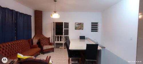 una sala de estar con un sofá y una mesa en Casa Condomínio Praia Félix, en Ubatuba