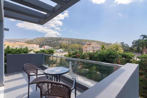 a balcony with a table and chairs and a mountain at Luxury modern villa with swimming pool, Athens Riviera in Lagonissi