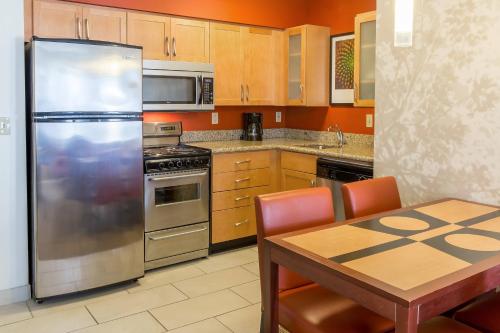 a kitchen with a stainless steel refrigerator and a table at Residence Inn by Marriott Sioux Falls in Sioux Falls