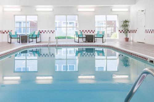 a pool in a hotel with chairs and tables at Residence Inn by Marriott Sioux Falls in Sioux Falls
