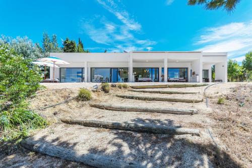 a house on a hill with logs in front of it at Xitaka Country House - Modern Large Great Views in Torres Novas