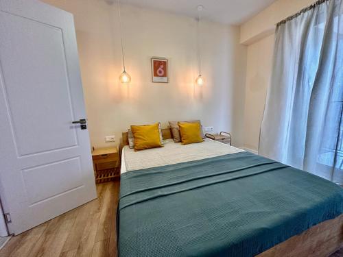 a bedroom with a bed with yellow pillows on it at All Green Loft with Amazing Views, With 2 Balconies and AC in Tbilisi City