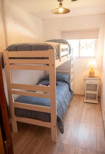 a bunk bed in a small room with a window at Complejo BenjaLuna in San Rafael