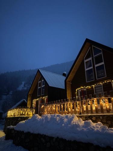 a house decorated with lights in the snow at night at Villa in Rugovë, Kosovo in Lekaj