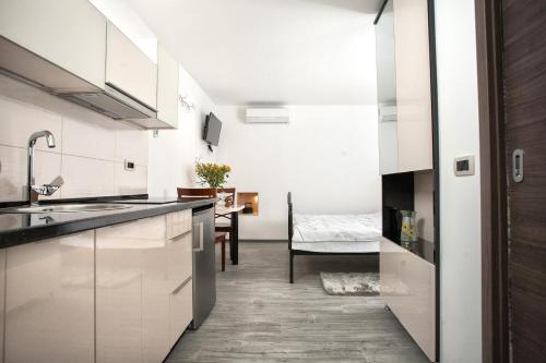 a kitchen with white cabinets and a dining room at Apartments & Room Kartolina in Split