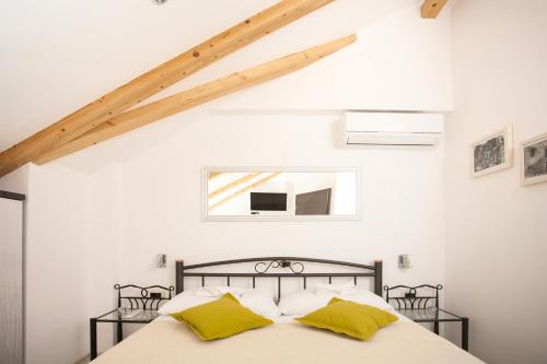 a bedroom with a bed with yellow pillows at Apartments & Room Kartolina in Split