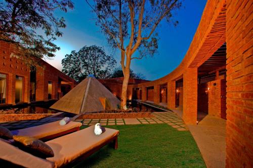 a courtyard with couches and a tree in a building at The Westin Sohna Resort & Spa in Gurgaon