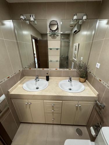 a bathroom with two sinks and a large mirror at Atico acogedor con vistas in Telde