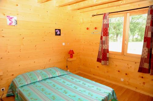 une chambre avec un lit dans une cabane en rondins dans l'établissement DROUVENANT chalet 10 personnes, à Charcier