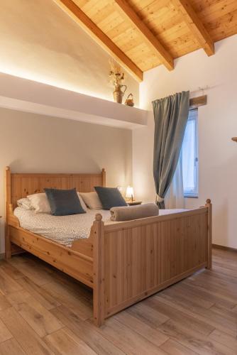 a large wooden bed in a room with a window at Il riccio di Ricciano in Casale Corte Cerro