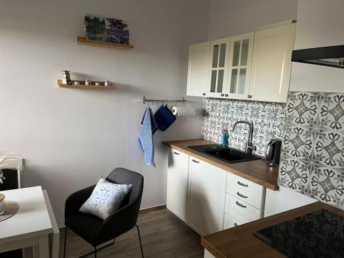 a small kitchen with a sink and a chair at sanierte ruhige Wohnung in der Natur mit Küche in Wettringen