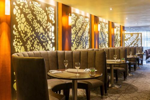 a restaurant with tables and chairs with wine glasses at The Westin Cape Town in Cape Town