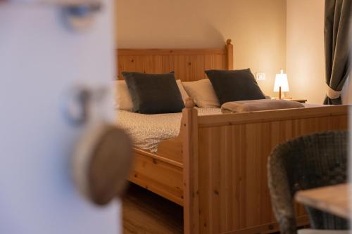 a bedroom with a wooden bed with black pillows at Il riccio di Ricciano in Casale Corte Cerro