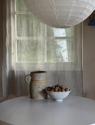 a vase and a bowl of nuts on a table at Atelier Blå houses in Rösselvik
