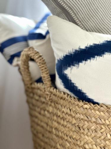 a wicker basket with pillows on a table at Atelier Blå houses in Rösselvik