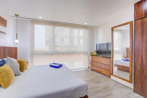 a bedroom with a large bed and a television at Porto 15 Condominios in Puerto Vallarta