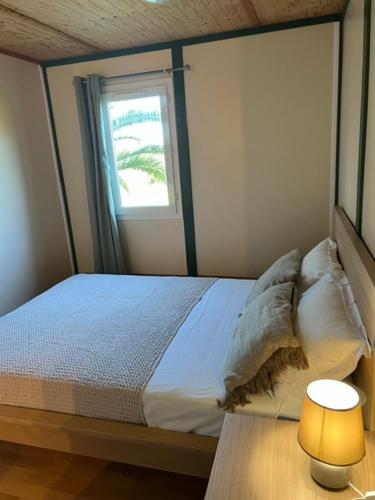 - une chambre avec un lit doté d'une fenêtre et d'une lampe dans l'établissement La vallée 2, à Belvédère