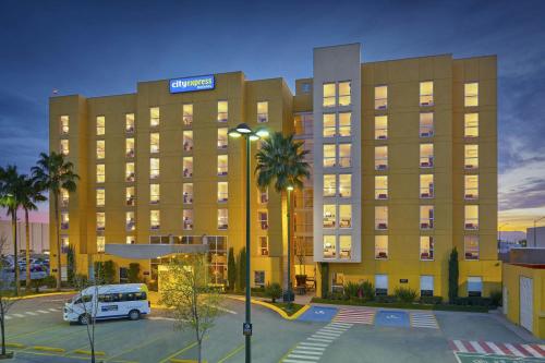 a hotel with a van parked in a parking lot at City Express by Marriott Torreon in Torreón